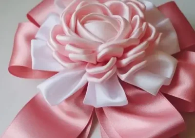 A pink bow adorned with white polka dots, elegantly tied and ready for decoration or gift wrapping