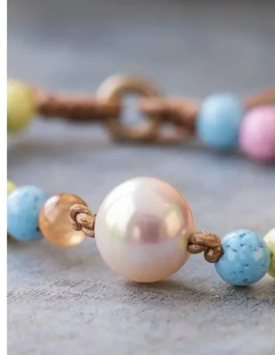 1. A vibrant bracelet featuring an array of colorful beads interspersed with a single elegant pearl. 2. A stylish bracelet adorned with a mix of colorful beads and a central pearl, showcasing a playful yet sophisticated design. 3. A charming bracelet composed of various colorful beads, highlighted by a beautiful pearl, perfect for any occasion.